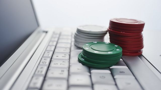 Plataforma de jogos online, casino e negócios de jogos de azar. cartas e  dados no teclado do laptop, em tons de azul.