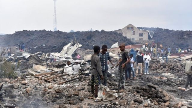 Des habitants ramassent les restes de leurs maisons détruites par la lave incandescente déposée par l'éruption du volcan Nyiragongo près de Goma, en République démocratique du Congo, le 23 mai 2021.