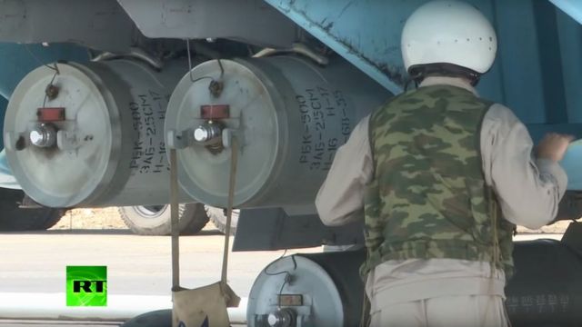 Soldado ao lado do que parece ser uma bomba de fragmentação RBK-500