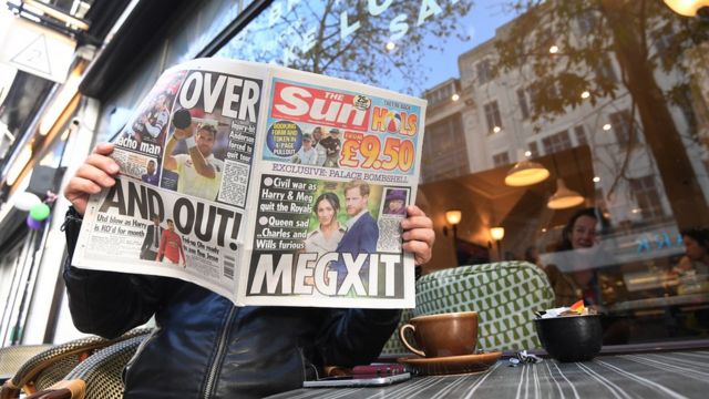Persona leyendo el periódico The Sun en el que se habla de la decisión del príncipe Harry y su esposa Meghan de alejarse de la familia real