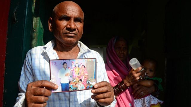 Un hombre sostiene la foto de Janki Bai, una mujer que murió en la esterilización colectiva.