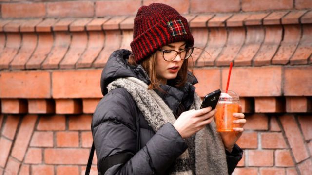 Mulher com seu telefone celular