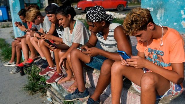 Cubanos usando celular