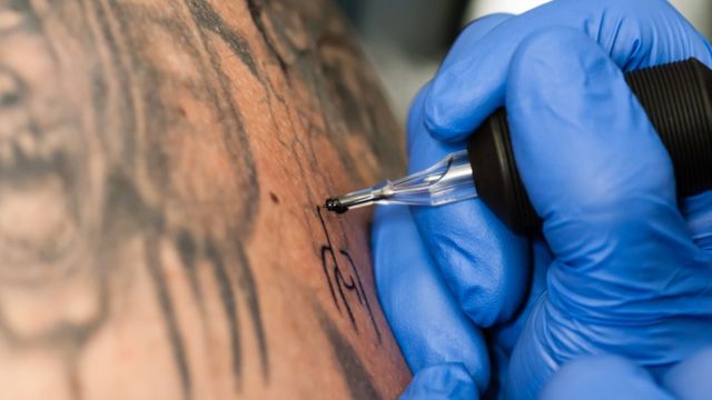 Tatuador tatuando una espalda