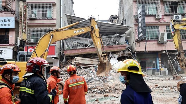 عمال الإنقاذ في موقع المبنى الذي انهار يوم الجمعة في مدينة شانغشا في الصين - 29/4/2022