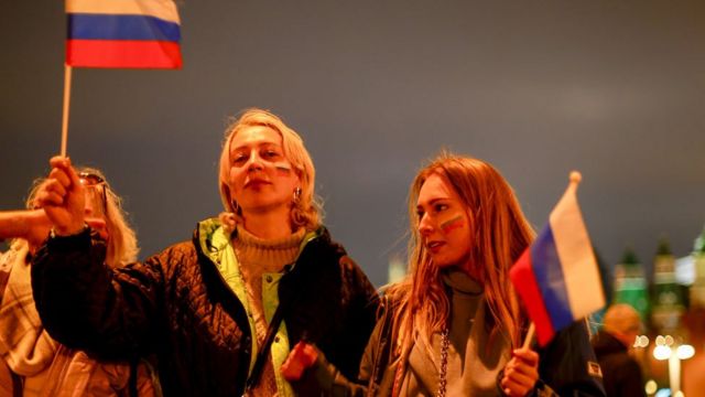 Dos mujeres rusas celebran la anexión de cuatro regiones de Ucrania.