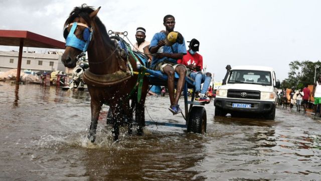 Une charrête assurant le transport sur une route inondée à Dakar