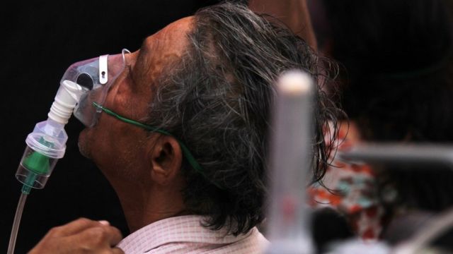 A man suffering from a breathing difficulty due to the coronavirus disease (COVID-19), receives free oxygen support outside a Gurudwara (Sikh temple) in Ghaziabad, India on April 28, 2021. India touched another grim milestone as the overall deaths in the pandemic crossed the 2-lakh mark. Over 3.6 lakh new cases were reported in the last 24 hours in yet another single-day record. (Photo by Mayank Makhija/NurPhoto via Getty Images)