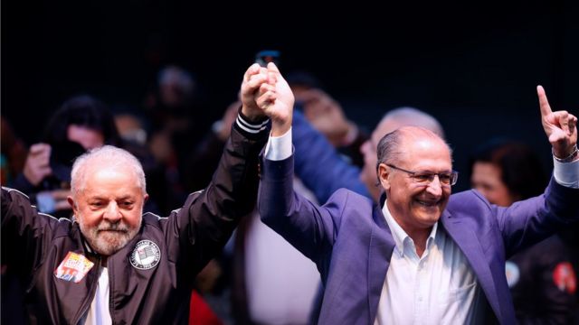 Lula e Alckmin de mãos dadas e levantando o braço em comemoração