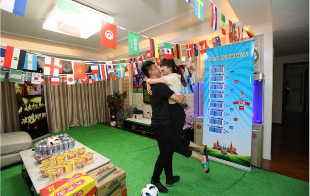 6月12日,中國鄭州一對夫婦在家布置迎接世界杯。