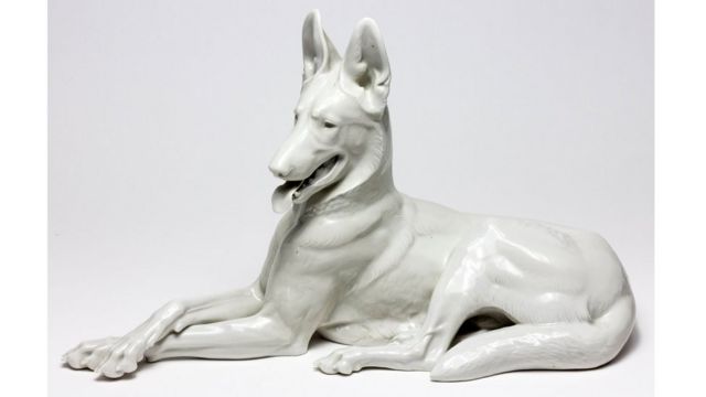 Escultura blanca de porcelana de un perro alsaciano.