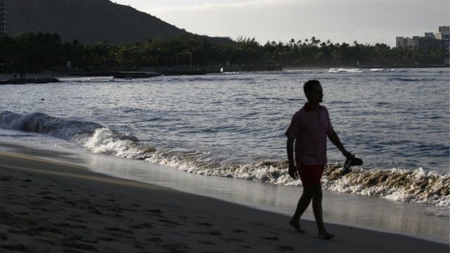 Un hombre camina por Playa Waikiki, Honolulu.