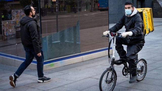 Un repartidor con mascarilla en una calle de Madrid.