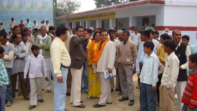 A family from Trinidad looks at the school their grand dad built in India