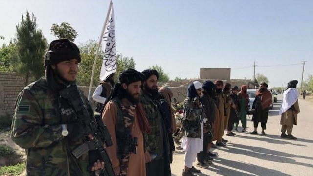 Milicianos del Talibán forman una fila al lado de una carretera