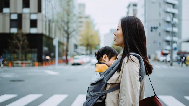 Madre con su bebé caminando en la calle