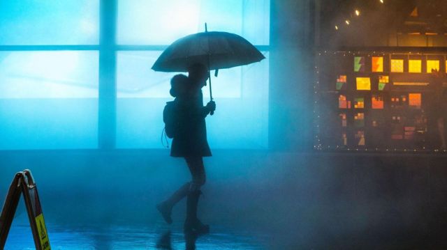 La silueta de una mujer caminando en la lluvia