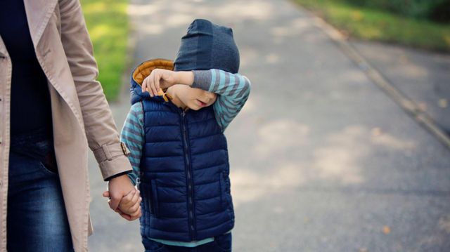 criança de mãos dadas com a mãe