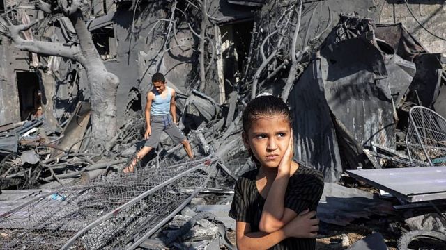 Niños en Gaza en medio de ruinas de edificios