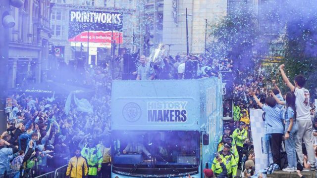Manchester City's open top bus parades through the streets of Manchester