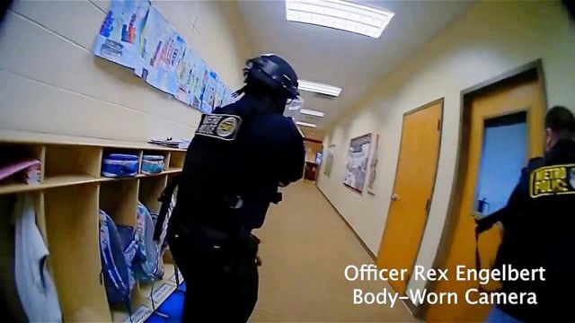 Câmera corporal mostra dois policiais mirando armas em corredor de escola