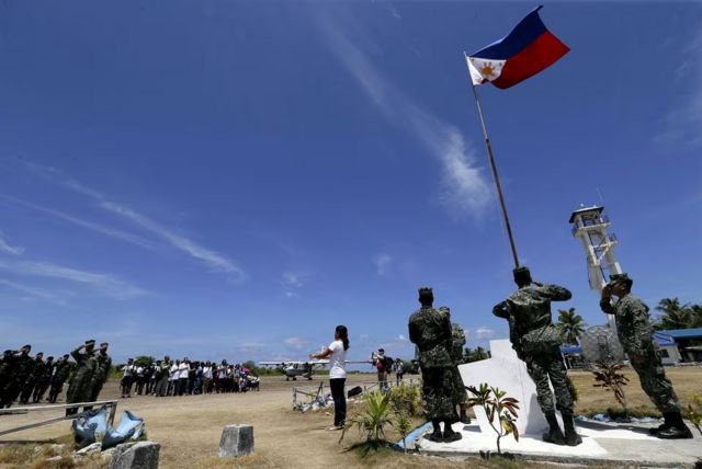 Người dân và binh sĩ Philippinies làm lễ thượng cờ trên đảo Thitu (Philippines gọi là Pagasa, Việt Nam gọi là Thị Tứ) vào ngày 11/05/2015