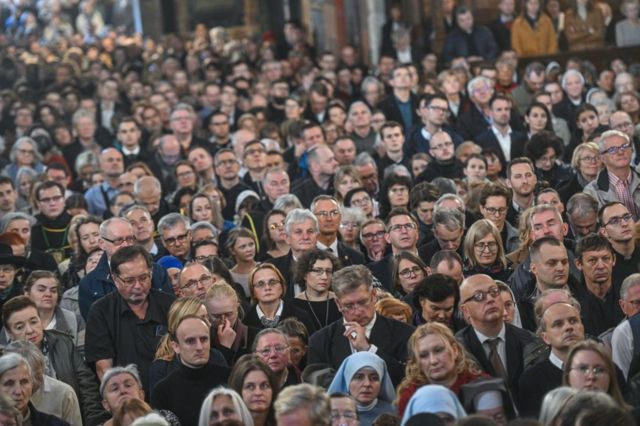 Un grupo de personas asiste a un funeral