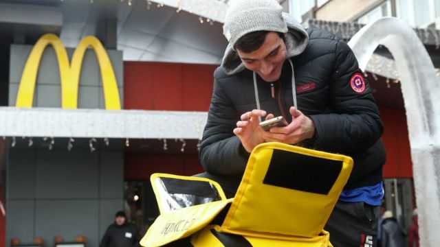 Food courier outside the first McDonald's that opened in Russia