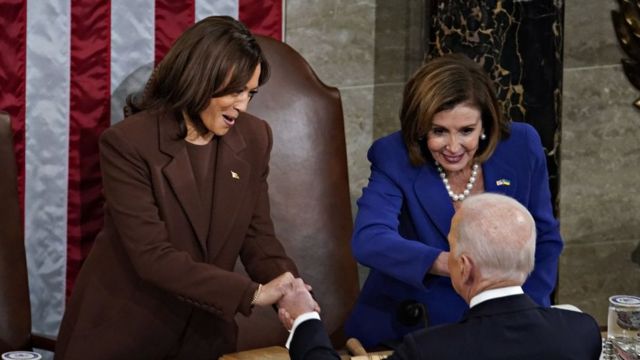 El president Joe Biden salutes Nancy Pelosy and Kamala Harris at a discreet terminus.