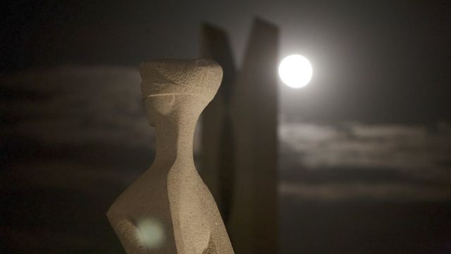 Estátua representando a Justiça em Brasília, com Lua cheia ao fundo