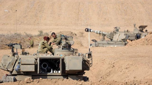 Israeli soldiers with armoured fighting vehicles at an area along the border with Gaza