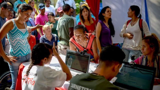 Personas registrándose en un punto rojo.
