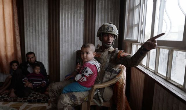 الملازم أول علاء يجلس مع مجموعة من المدنيين في كوكجلي. ومن المتوقع أن تستغرق عمليات الموصل أسابيع إن لم يكن شهورا