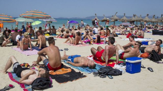 Turistas en una playa española.