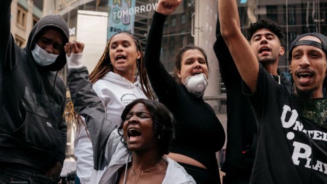 Manifestantes levantam os punhos em protesto contra o racismo