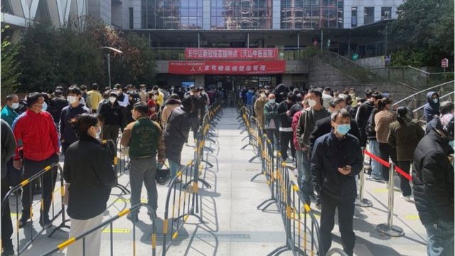 上海长宁区，人们在医院排队进行核酸检测。
