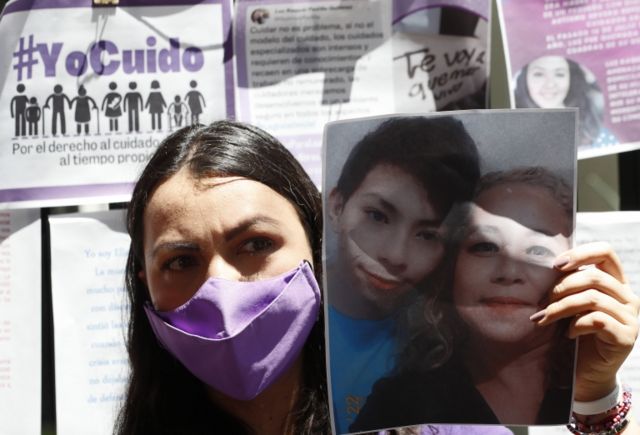 "Yo cuido México" organizasyonundan bir protestocu Padilla ve oğlunun fotoğrafını kameralara gösteriyor