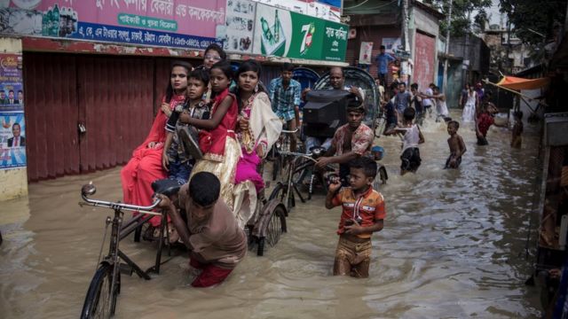 Pessoas movendo seus pertences em uma rua Chittagong