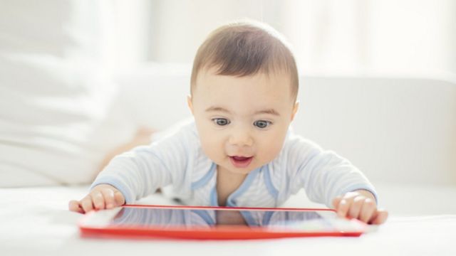 Bebê assistindo a tela de um tablet