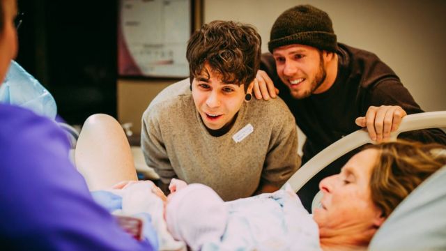 Parents Elliot Dougherty and Matthew Eledge meet their newborn daughter at the hospital.