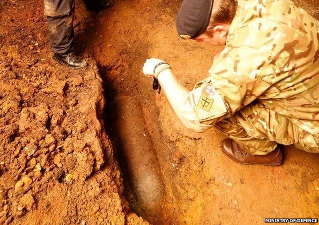 Bomb disposal experts examine the unexploded WW2 bomb