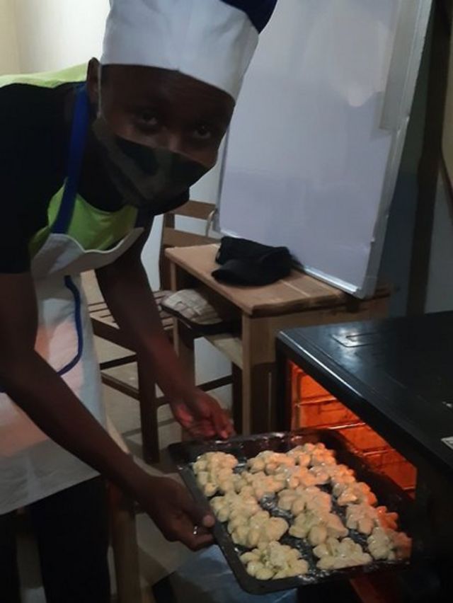 Justin putting a tray of bread into the oven