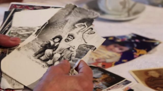 Старые черно-белые семейные фото на столе и в руках