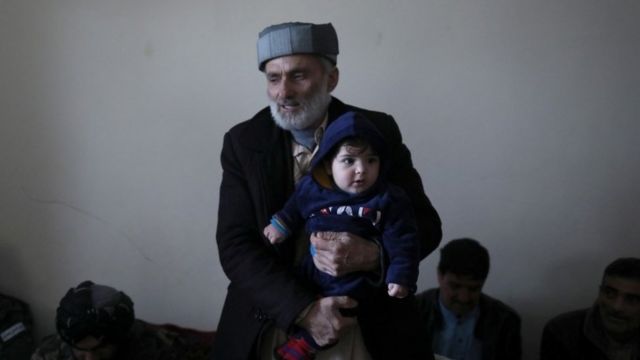 Mohammad Qasem Razawi, abuelo de Sohail Ahmadi, sostiene a su nieto.