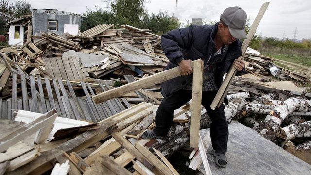 Un trabajador de Tayikistán recoge madera cerca de Moscú.