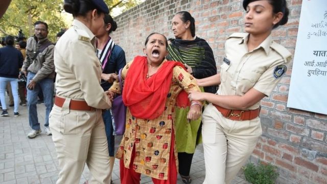 Gujarat Police officials detain a demonstrator during a peaceful protest against the Indian government's Citizenship Amendment Bill outside Indian Institute of Management (IIM) in Ahmedabad on Monday
