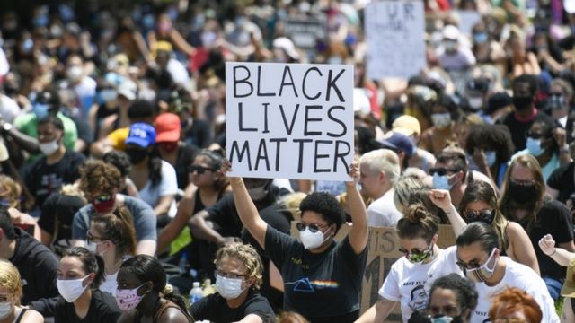 "Siyahların Hayatları Değerlidir" yazılı bir pankart taşıyan protestocu