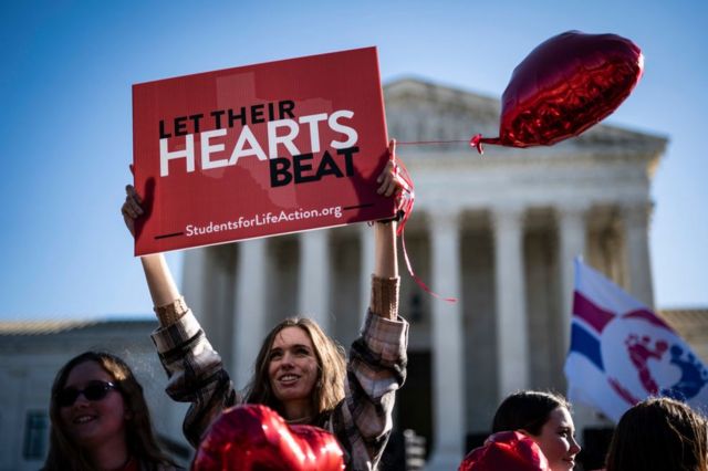 Um manifestante antiaborto segura uma placa que diz "deixe o coração deles bater" do lado de fora do Capitólio, em Washington, em novembro de 2021.