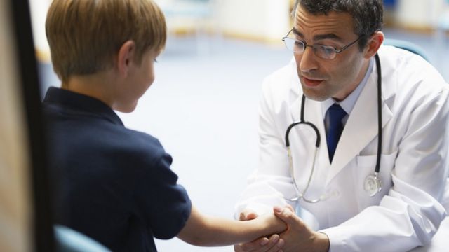 A doctor examines a child's hand