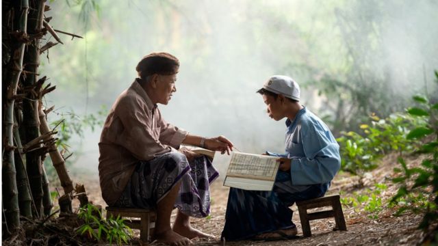 Un niño en Indonesia aprende a leer el Corán con su abuelo.